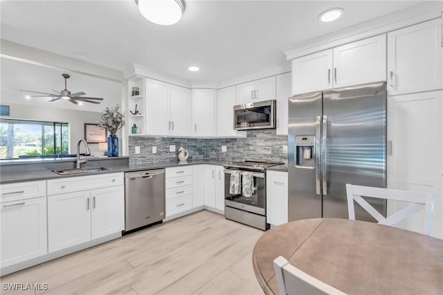 kitchen with white cabinetry, appliances with stainless steel finishes, sink, and decorative backsplash