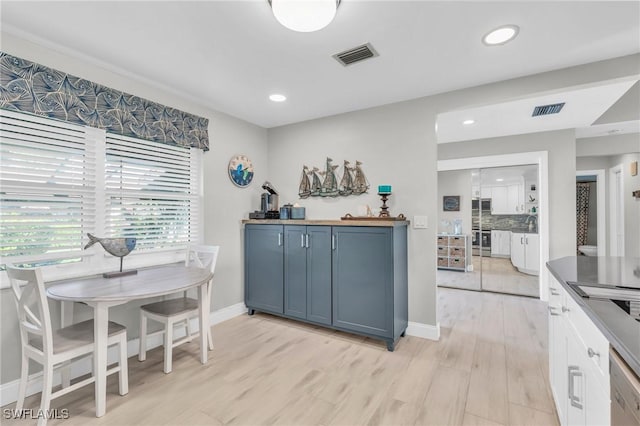 kitchen with dishwashing machine, decorative backsplash, light hardwood / wood-style flooring, and oven