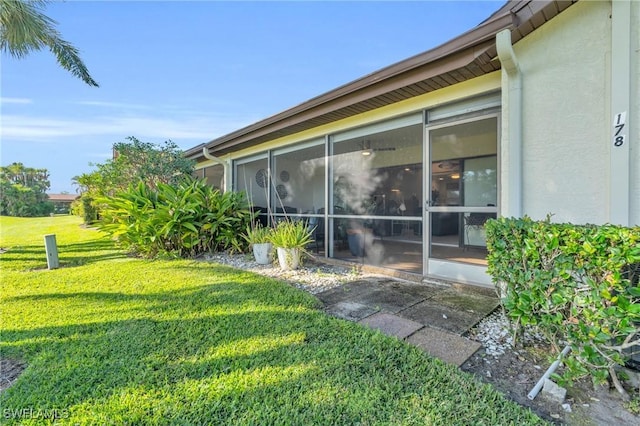 view of side of home featuring a yard and a sunroom