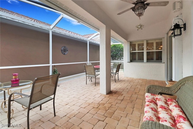 view of patio with glass enclosure and ceiling fan