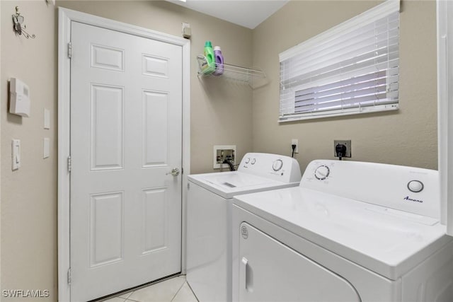 laundry area featuring washer and dryer and light tile patterned floors