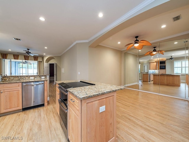 kitchen featuring ornamental molding, light stone counters, stainless steel appliances, and a kitchen island