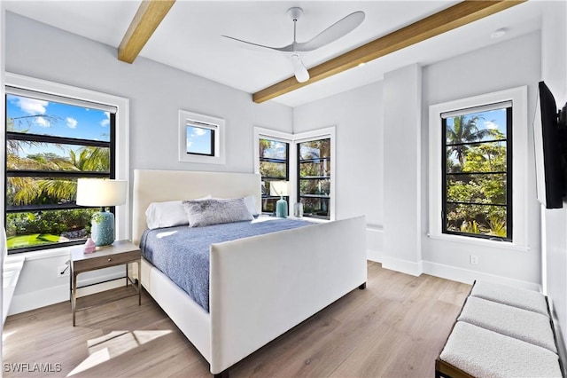 bedroom with ceiling fan, beamed ceiling, and hardwood / wood-style floors