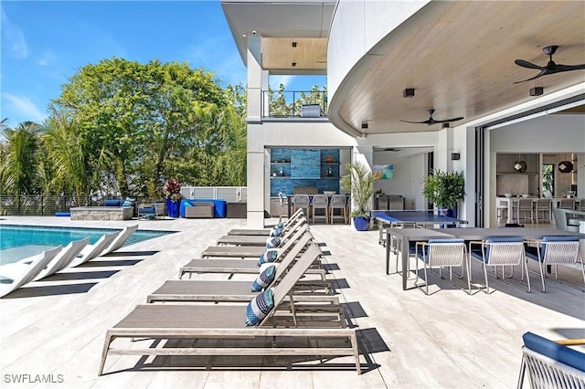 view of patio with ceiling fan, an outdoor bar, and a community pool