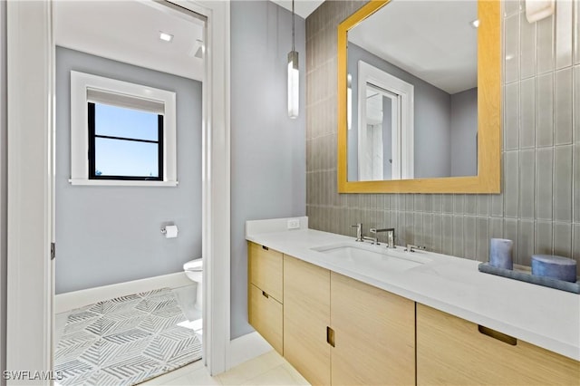 bathroom with toilet, vanity, tile patterned flooring, and tasteful backsplash