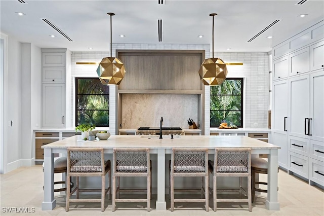 kitchen with a kitchen breakfast bar, breakfast area, a large island, and decorative light fixtures