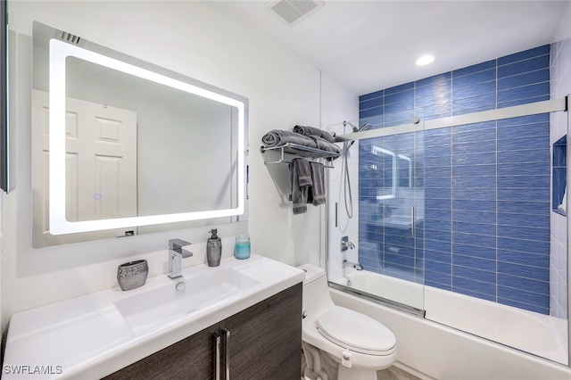 full bathroom featuring toilet, enclosed tub / shower combo, and vanity