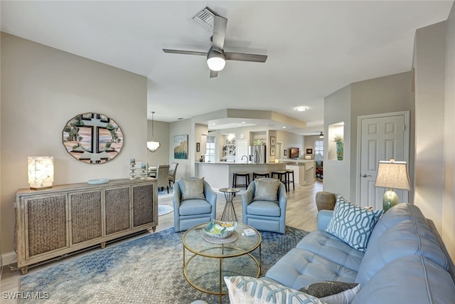 living room with ceiling fan and hardwood / wood-style flooring