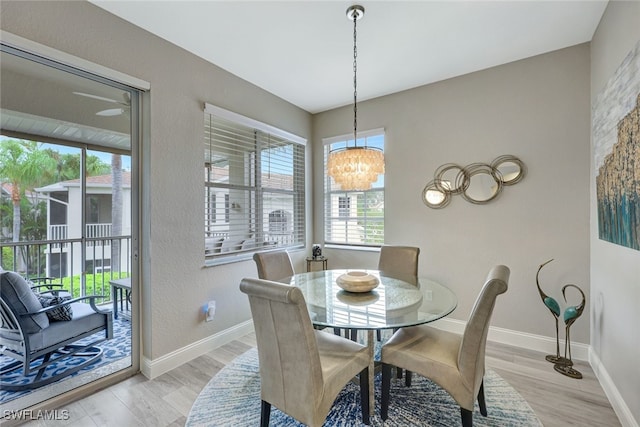 dining area featuring light wood-type flooring and a chandelier