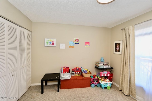 playroom with a textured ceiling and carpet flooring