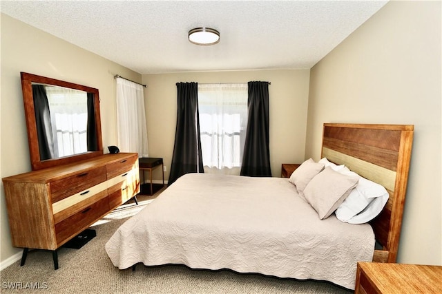 bedroom with a textured ceiling and carpet flooring