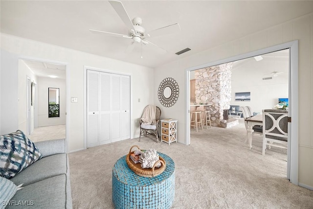 carpeted living room with ceiling fan