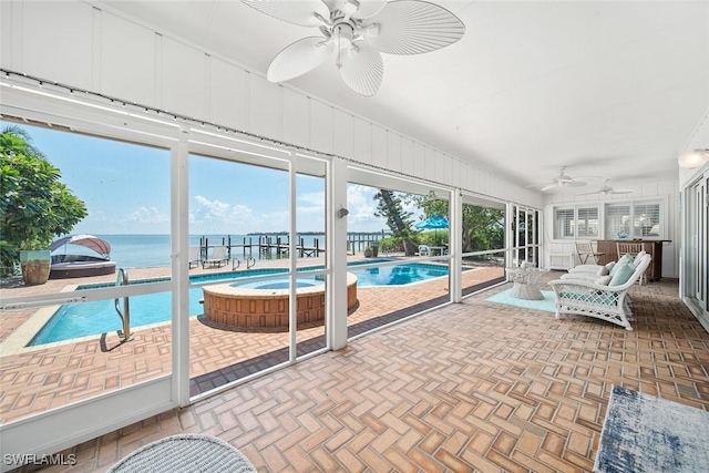 sunroom with a water view, a wealth of natural light, and ceiling fan