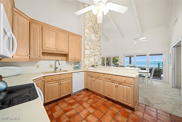 kitchen featuring sink, dark carpet, kitchen peninsula, a water view, and white appliances