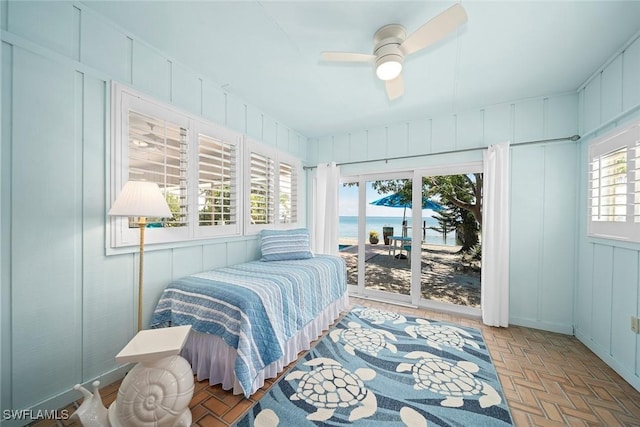 bedroom featuring light parquet floors, a water view, access to exterior, and ceiling fan