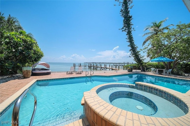 view of pool featuring an in ground hot tub and a water view