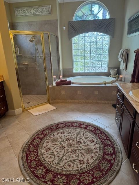 bathroom featuring vanity, tile patterned flooring, and separate shower and tub