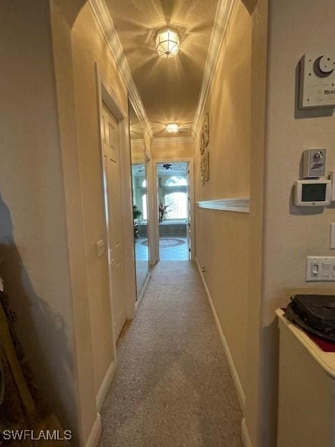 hallway featuring ornamental molding and light carpet