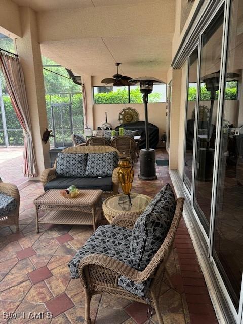 view of patio / terrace with ceiling fan, a lanai, and outdoor lounge area