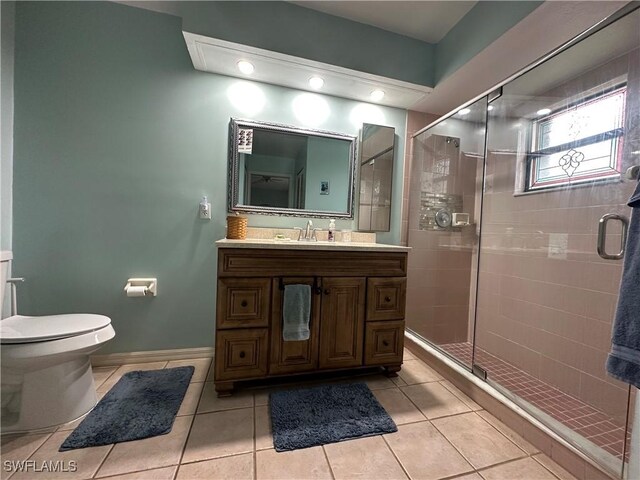 bathroom with an enclosed shower, vanity, tile patterned floors, and toilet