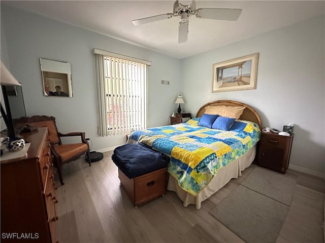 bedroom with ceiling fan, baseboards, and wood finished floors