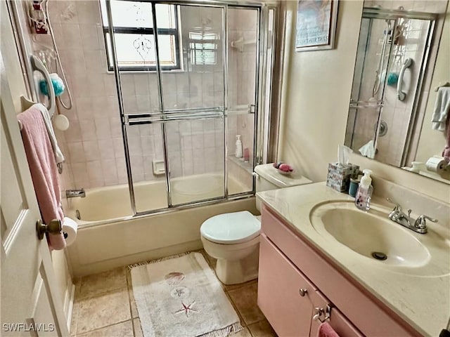 full bath with tile patterned floors, combined bath / shower with glass door, toilet, and vanity