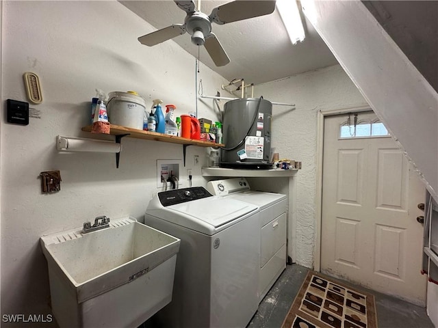 washroom with a sink, washer and dryer, water heater, laundry area, and a textured wall