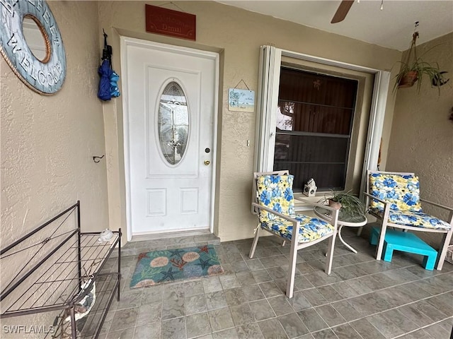 view of exterior entry with a porch and stucco siding