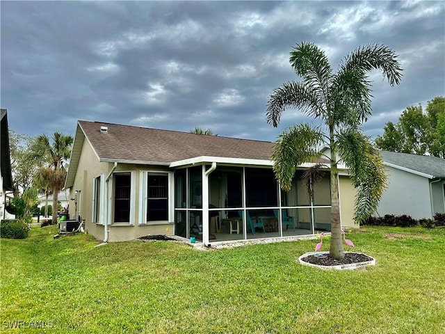 back of house with a yard and a sunroom