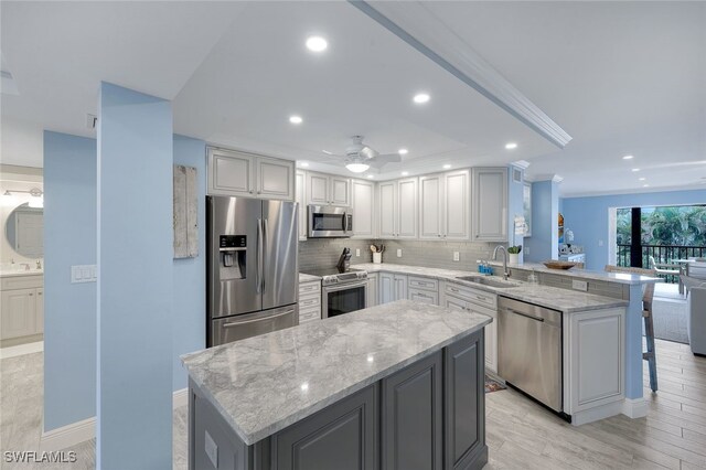 kitchen featuring a kitchen island, appliances with stainless steel finishes, sink, and kitchen peninsula