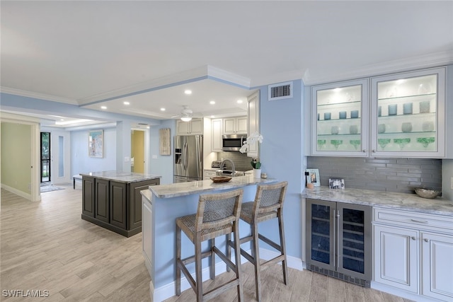 kitchen featuring light stone countertops, appliances with stainless steel finishes, tasteful backsplash, and a kitchen island