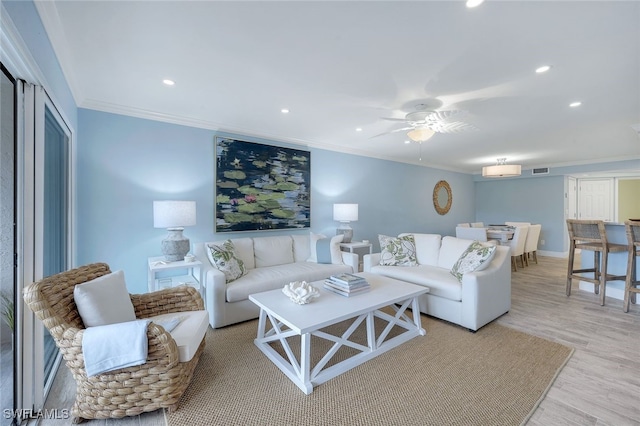 living room with light wood-style flooring, recessed lighting, visible vents, a ceiling fan, and crown molding