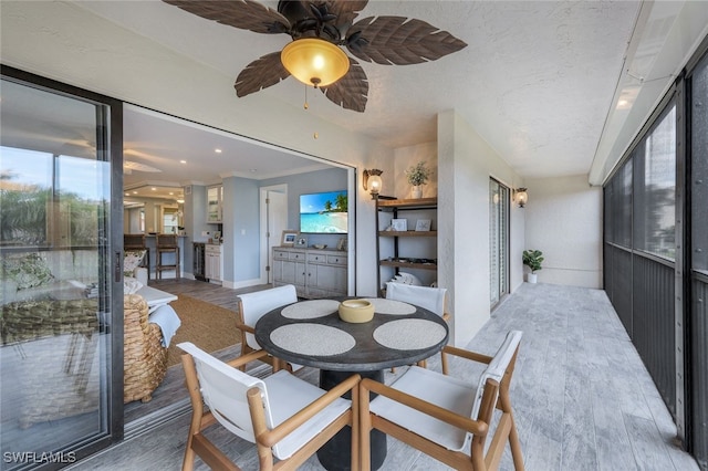 dining room featuring crown molding, ceiling fan, a textured ceiling, and wood finished floors