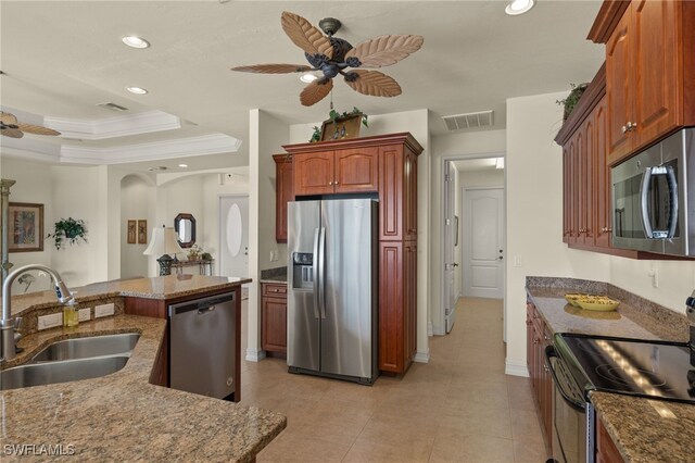 kitchen featuring a raised ceiling, sink, ceiling fan, stainless steel appliances, and crown molding