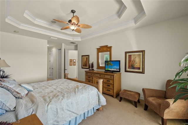 carpeted bedroom with a tray ceiling, ornamental molding, and ceiling fan