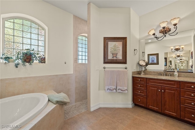 bathroom with vanity, tiled tub, and tile patterned flooring