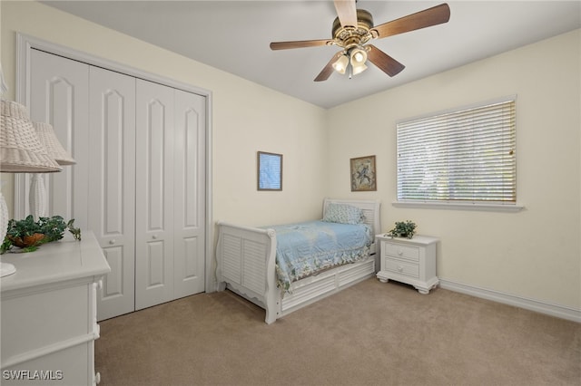 bedroom featuring ceiling fan, a closet, and light carpet