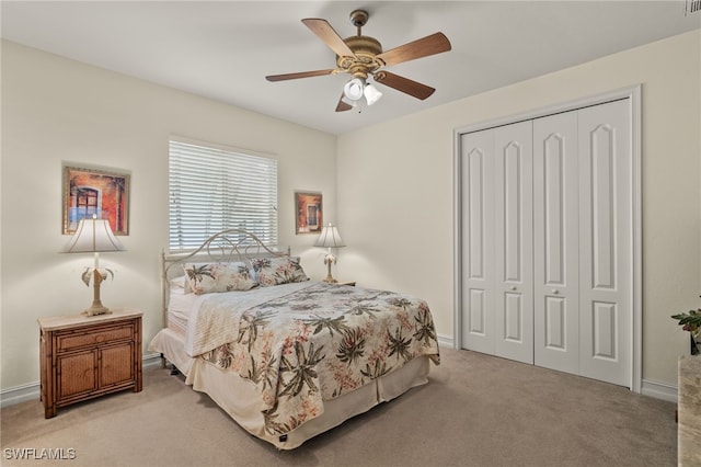 bedroom featuring light carpet, ceiling fan, and a closet