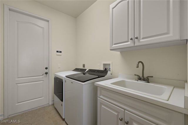 washroom with sink, washer and clothes dryer, and cabinets