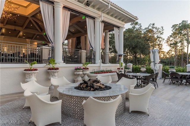 patio terrace at dusk featuring a fire pit and a gazebo