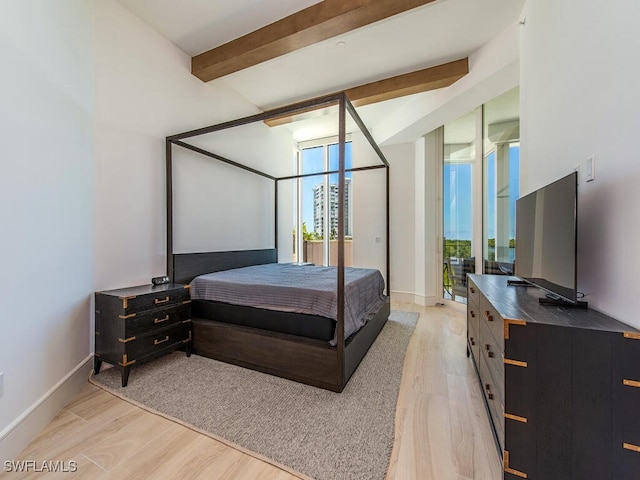 bedroom with beam ceiling and light hardwood / wood-style floors