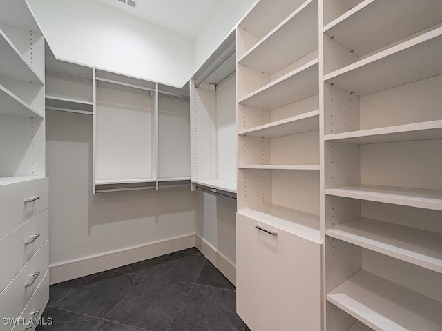 walk in closet with dark tile patterned floors