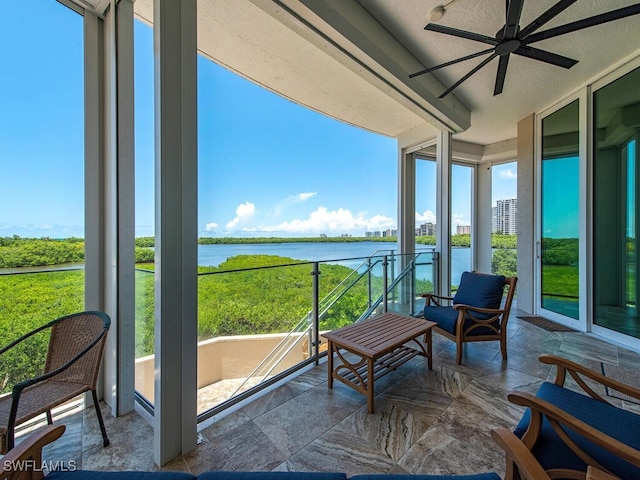 sunroom / solarium featuring ceiling fan and a water view