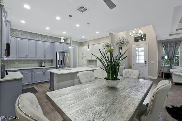 dining area with dark hardwood / wood-style floors, sink, and a notable chandelier