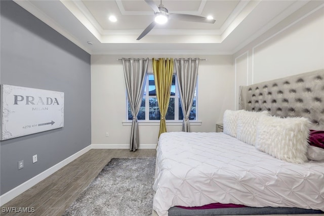 bedroom with crown molding, ceiling fan, a tray ceiling, and hardwood / wood-style floors