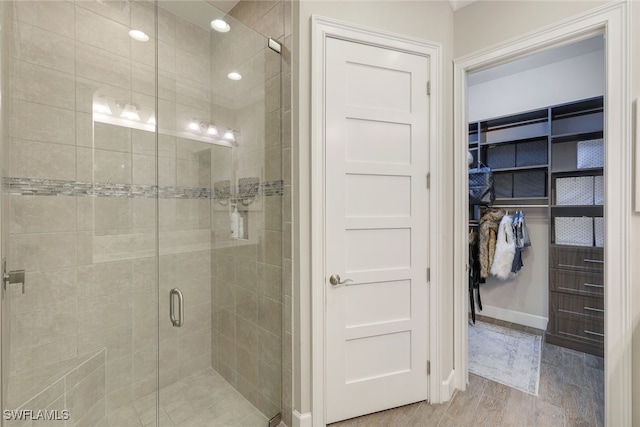 bathroom with wood-type flooring and a shower with shower door