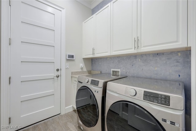 washroom with light hardwood / wood-style flooring, washer and clothes dryer, ornamental molding, and cabinets