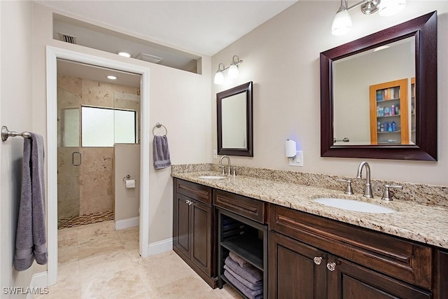 bathroom featuring a shower with shower door and vanity