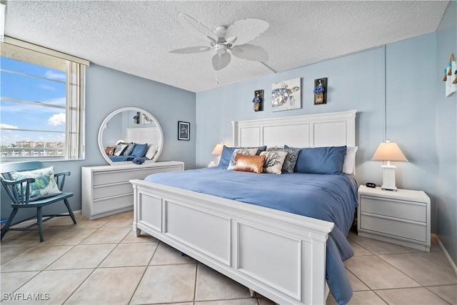 bedroom featuring light tile patterned floors, ceiling fan, and a textured ceiling