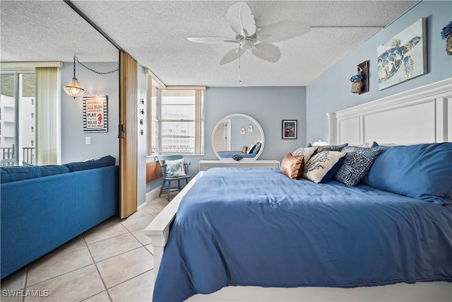 bedroom with light tile patterned floors, ceiling fan, access to outside, and a textured ceiling